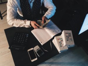 man counting cash and cell phones