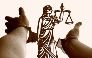 handcuffs against the scales of justice