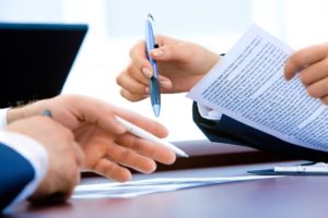 lawyers at a meeting, documents, signing paperwork